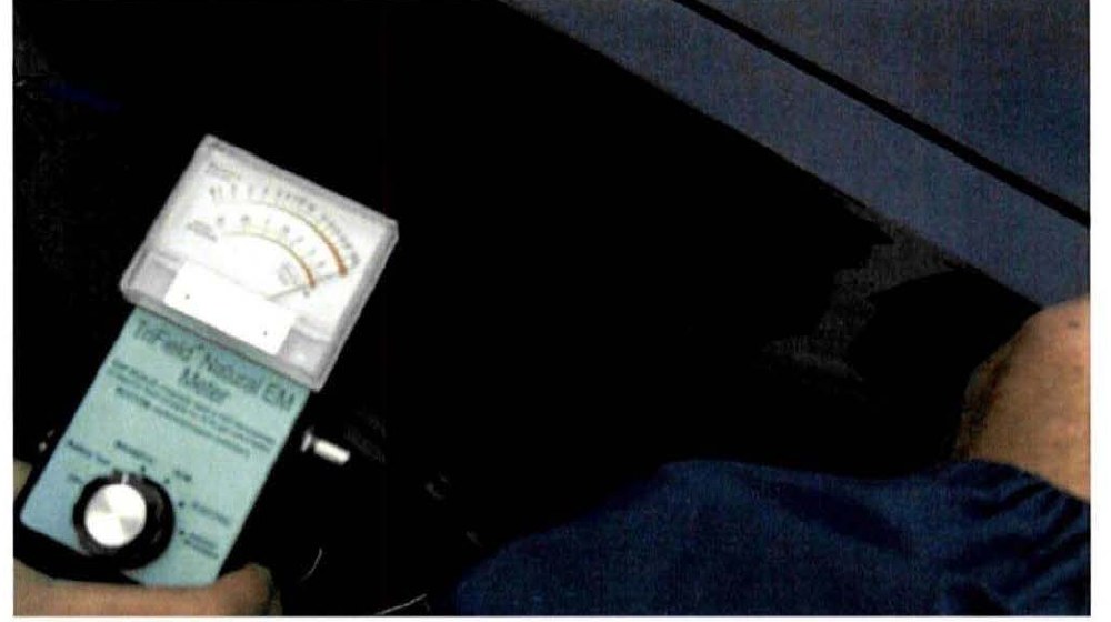 DOW-UAP-D173: TriField Natural EM meter held at the witness's car in MUFON case 20706, Port Jervis, New York (November 2009). Printed caption: "SUBJECT VEHICLE - Driver's side rear engine compartment magnetic field reading. (Full intensity needle pegged)".